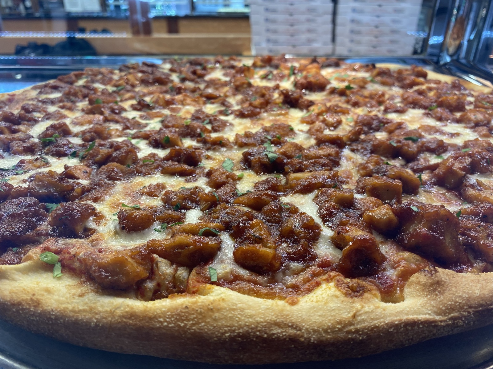 BBQ chicken pizza with melted mozzarella and fresh herbs